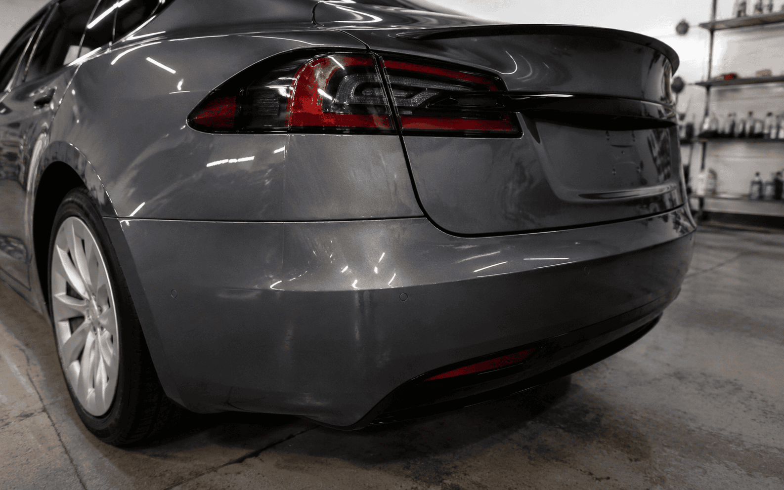 Controlled spray-booth curing during Tesla Model S panel refinishing.