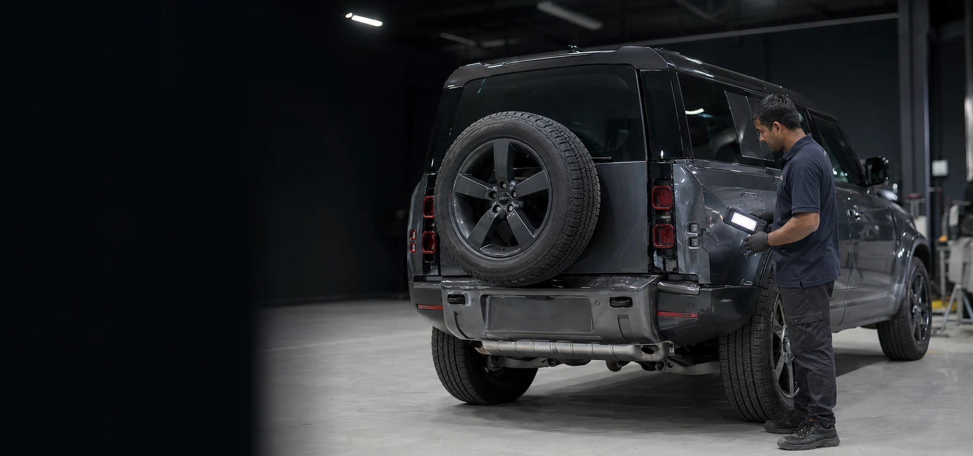Land Rover Defender undergoing body and accessory impact inspection in a professional Dubai workshop