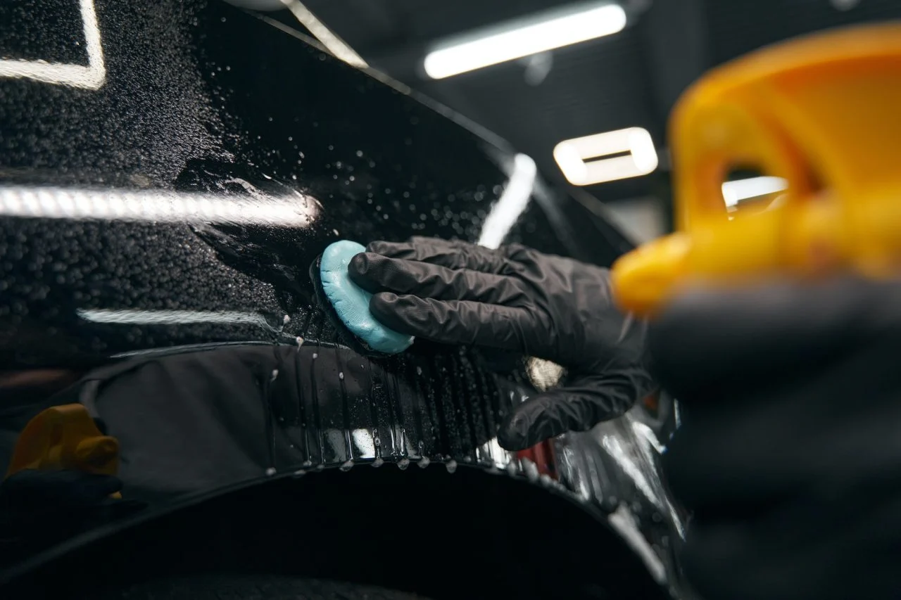 Machine polishing a car panel in a detailing workshop