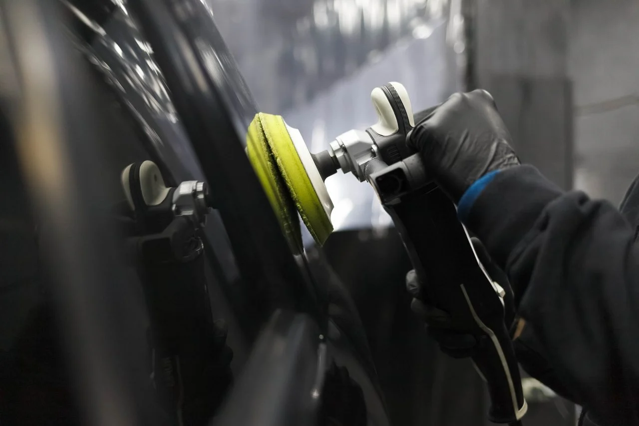 Technician refining a repaired vehicle surface